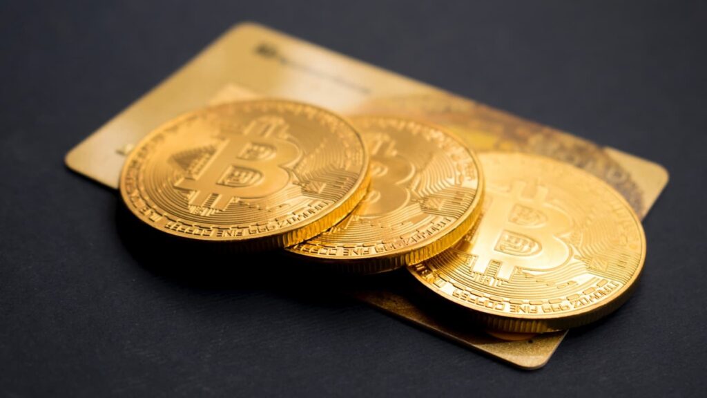 Três tokens Bitcoin dourados redondos - Freebitcoin