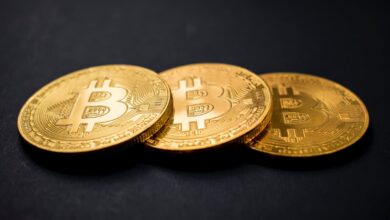 Fundo preto, três moedas de bitcoin - O que é bitcoin?