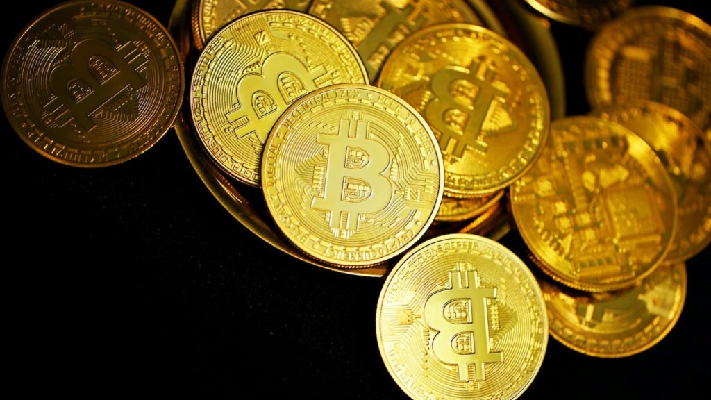 Fundo preto, diversas moedas de bitcoin - O que é bitcoin?