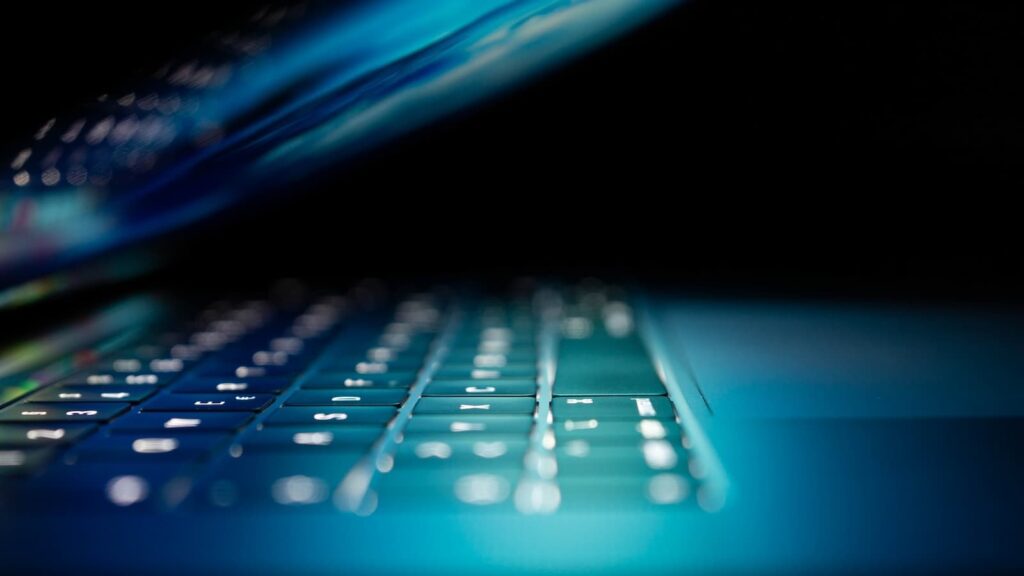Foto aproximada do computador portátil azul e branco ligado - Foto: unsplash - O que é o WormGPT?