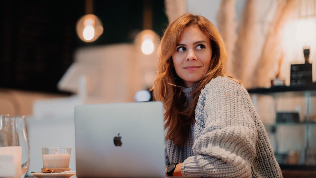 Uma mulher sentada na frente de um computador portátil - Livro Sobre Autoestima e Amor Próprio